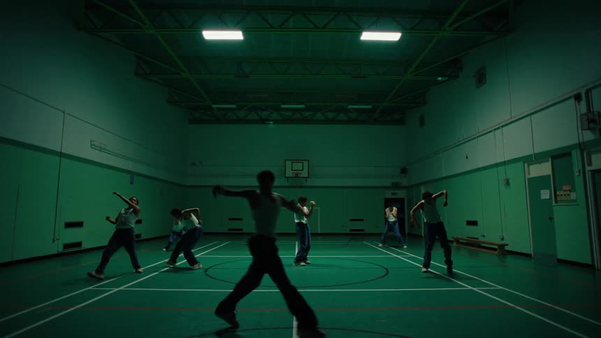 Multiple exposures of a man dancing on a lit basketball court