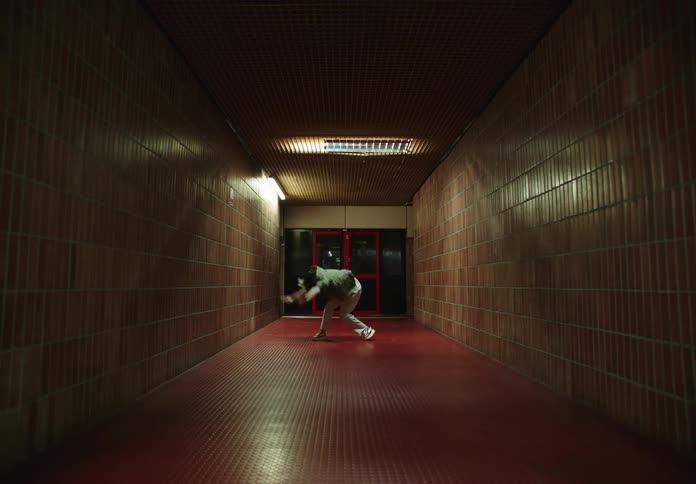 Woman in a nightlit hallway dancing