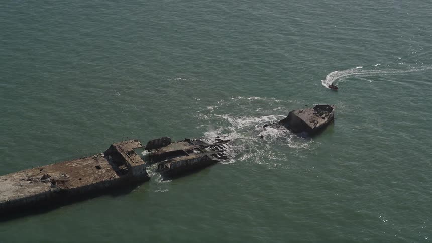 The remnants of a large ship lie broken and scattered in the ocean