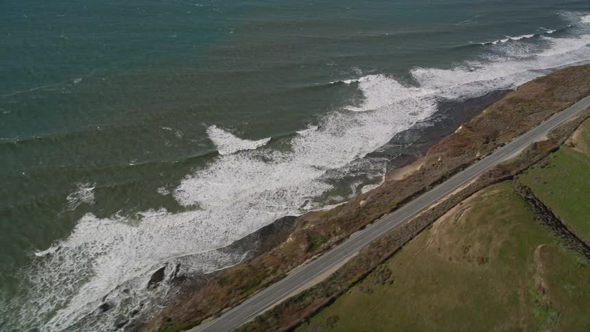 Highway with vehicle traffic on rocky coast and seaside