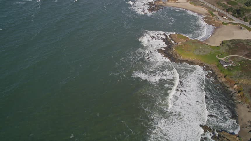 View from above of the rocky greenish coast by the sea