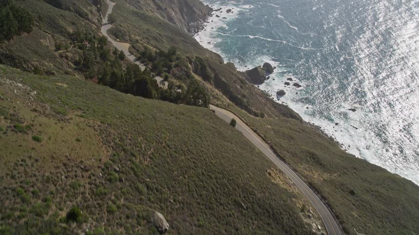 Top view of a winding road through the mountains by the sea
