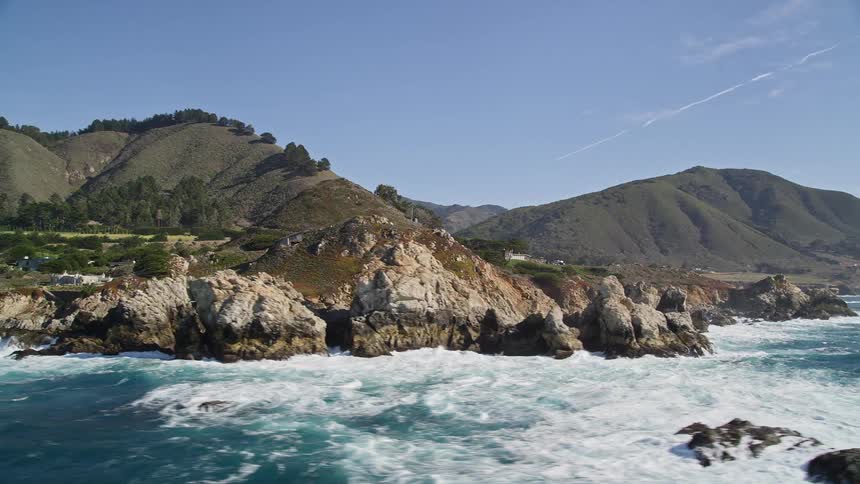 Mountain range by the sea on a clear blue sky day