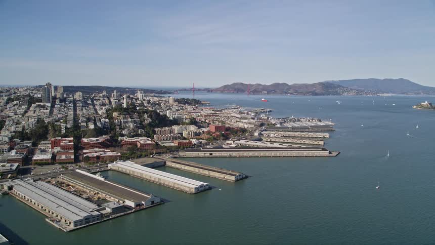 Panorama of a metropolis by the sea with docks and mountains on the horizon