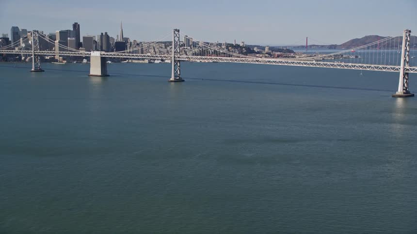 Landscape and an extensive bridge over the sea with a metropolis with large buildings in the background