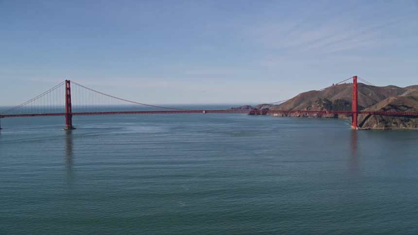 The golden gate bridges international orange towers rise majestically from the water its suspension cables stretching across the golden gate strait like a spider web