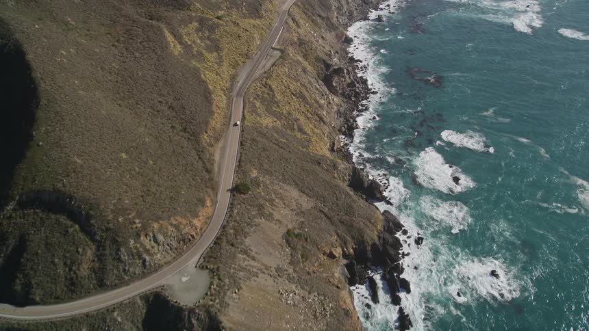 The scenic highway winds down the rocky cliffs along the california coastline