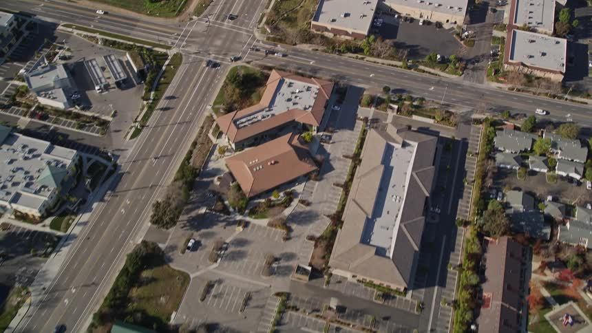 Aerial scenery of an extensive highway that passes through residential neighborhoods and sports fields