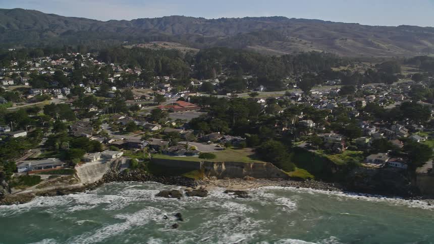Aerial view of a coastal town between the beach and the mountains