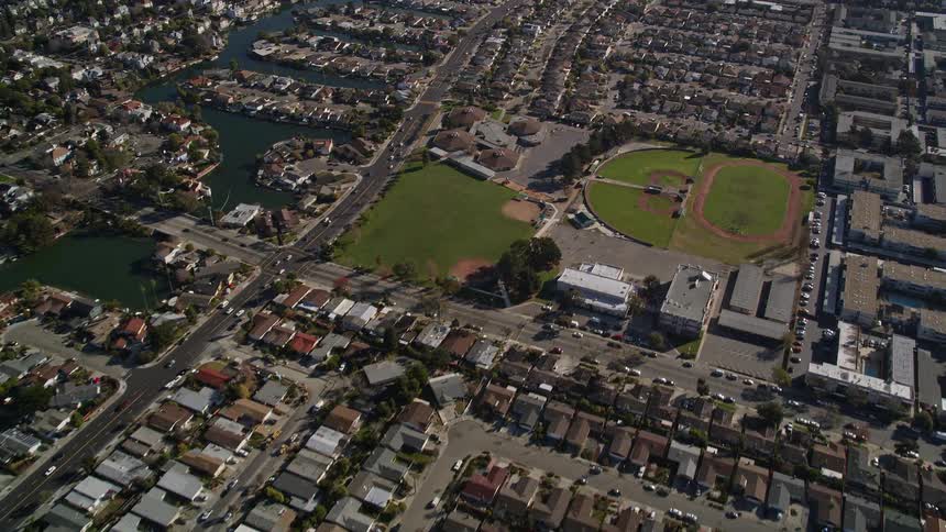 Aerial panorama of a residential town with a lake and sports fields