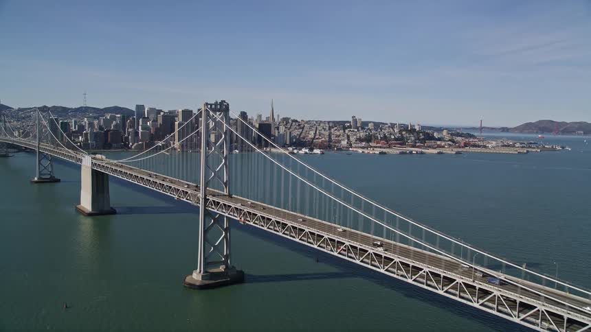 Aerial panorama of a vast bridge over the sea and metropolises on the horizon with skyscrapers