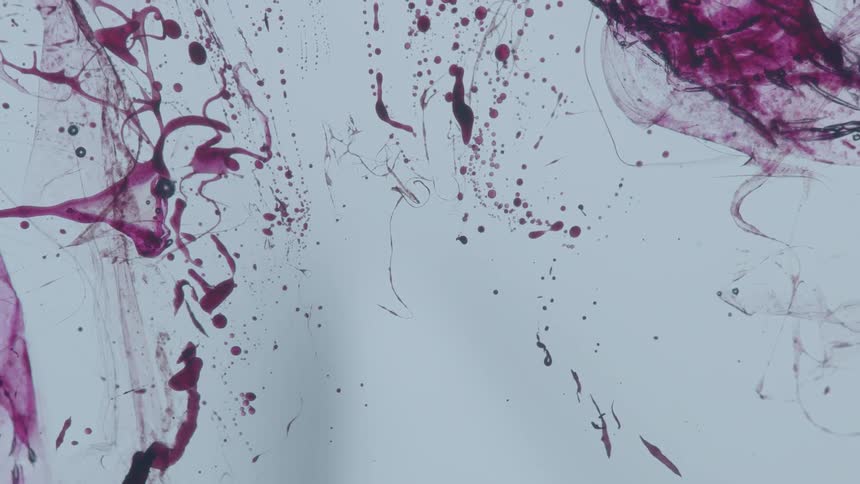 Red liquid is being splattered on a white wall