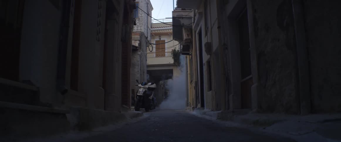 Smoke billows in an alley