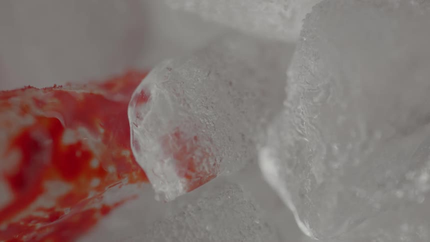 A red liquid flows over clear crystals