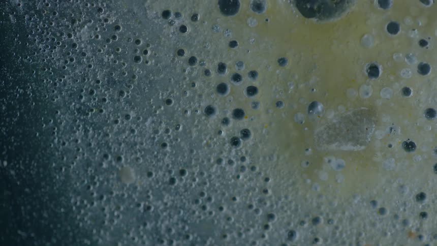 Bubbles in a white and yellow liquid