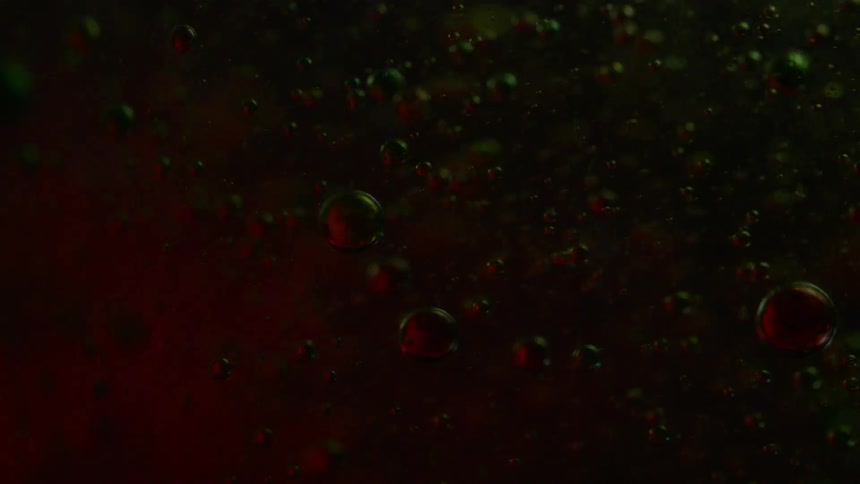 Liquid bubbles flowing with different colored lights flashing upon them