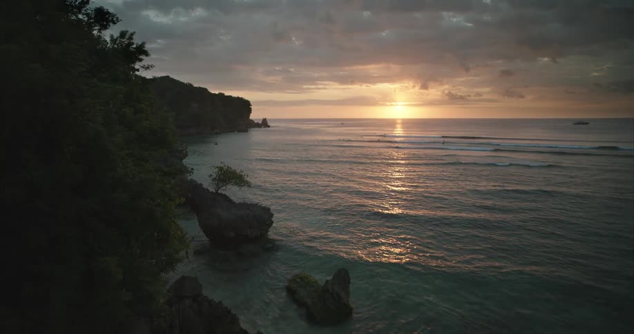 The sun is rising on the shore