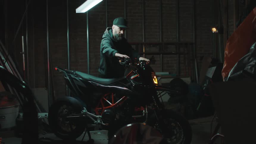 Male mechanic inspects a motorcycle parked in a garage