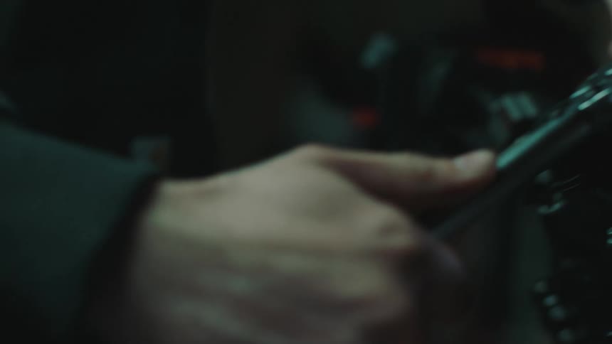 Hands of a man with a specific key working on a motorcycle