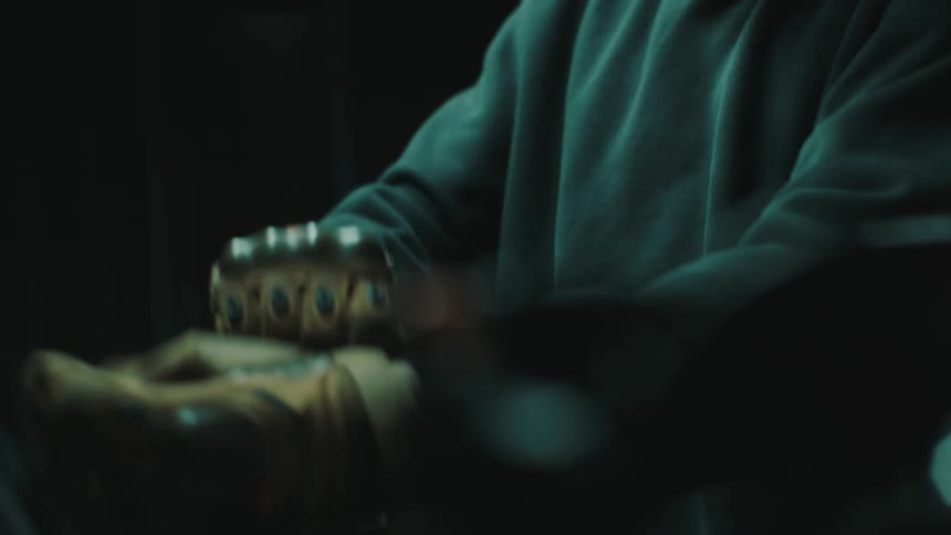 Man putting on leather gloves indoors