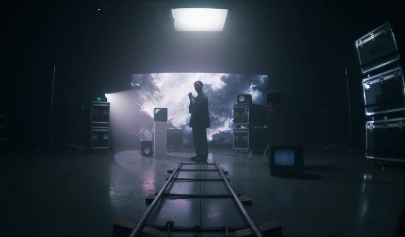 Man standing in a studio environment against a screen with clouds