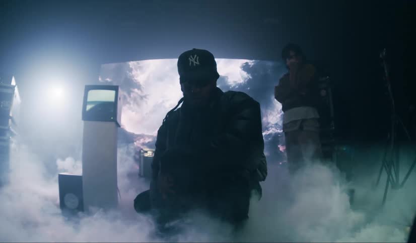 Three male models in a studio with dense smoke and abstract vintage electronics and a screen in the background