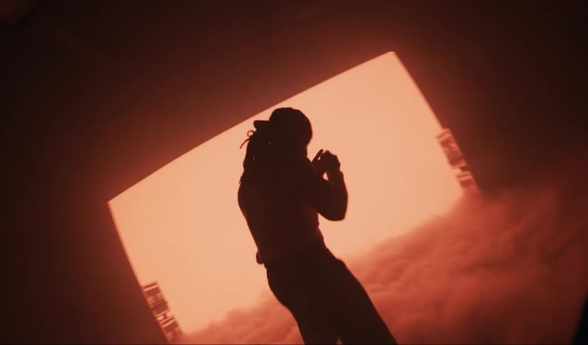 Man punching the air in a studio with artificial smoke on a flashing red screen