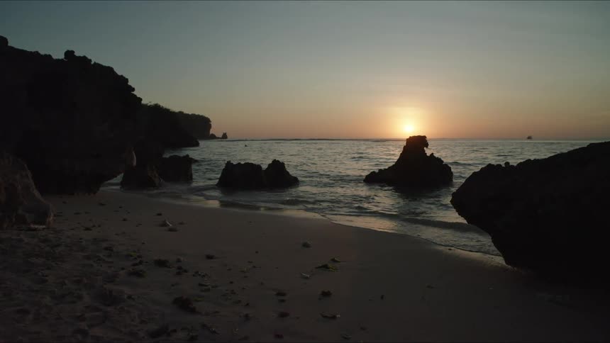 The sun is setting on the beach