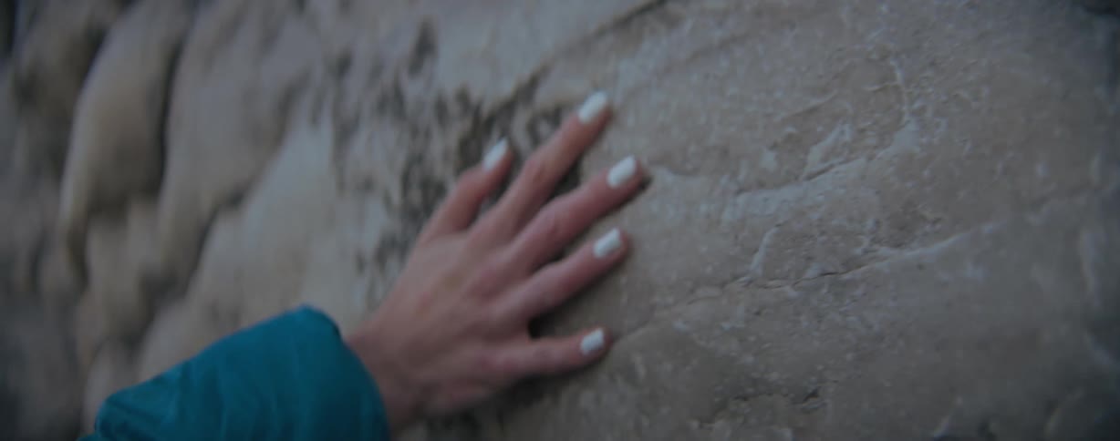 Woman's hand touching along on a rock