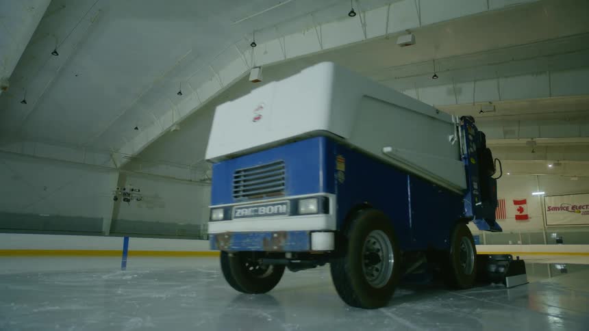 A man is riding the zamboni over the ice
