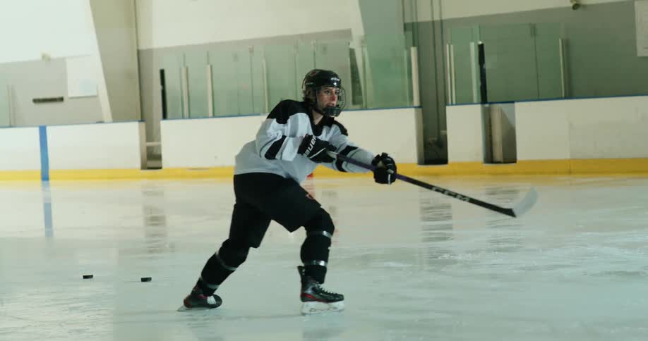 Woman on an ice court shooting balls in a hockey sport