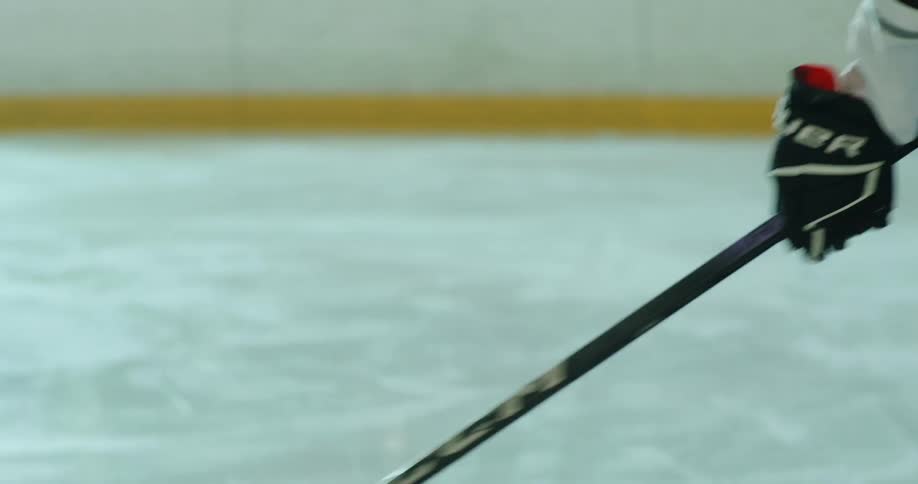 A hockey player pushes the puck around on the ice