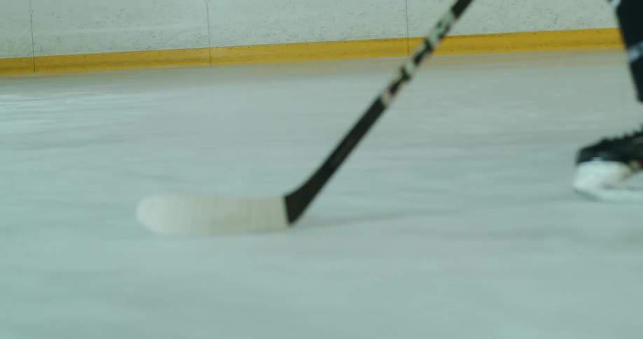 Person driving a hockey puck across a court