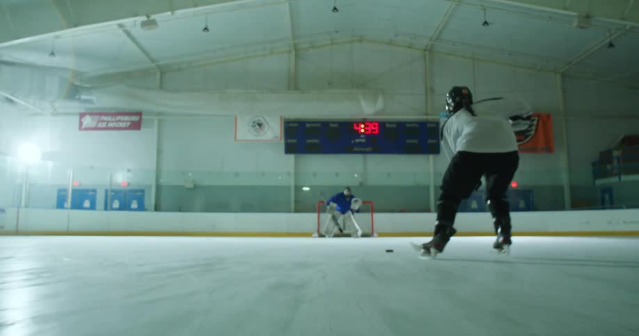 A goalie blocks the puck while playing hockey
