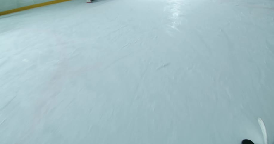 Hockey player moves the puck across the ice and takes a shot