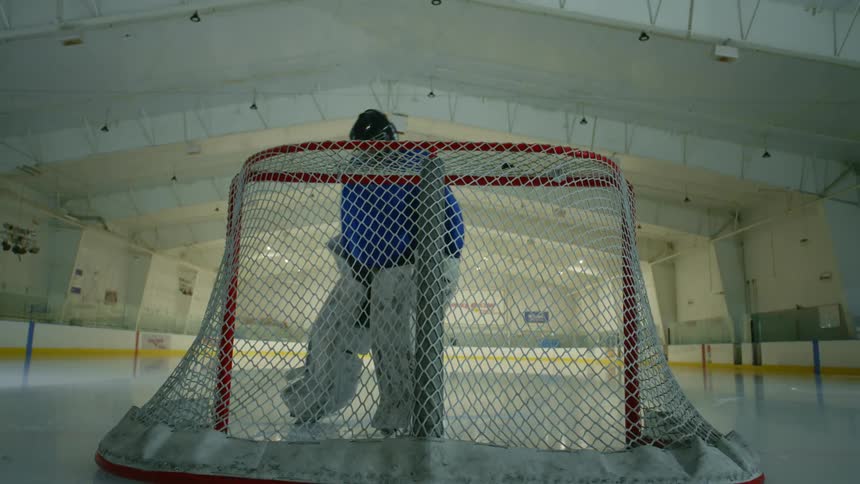 Person going towards the goal on a hockey rink