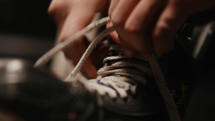 Hands of a person lacing skates
