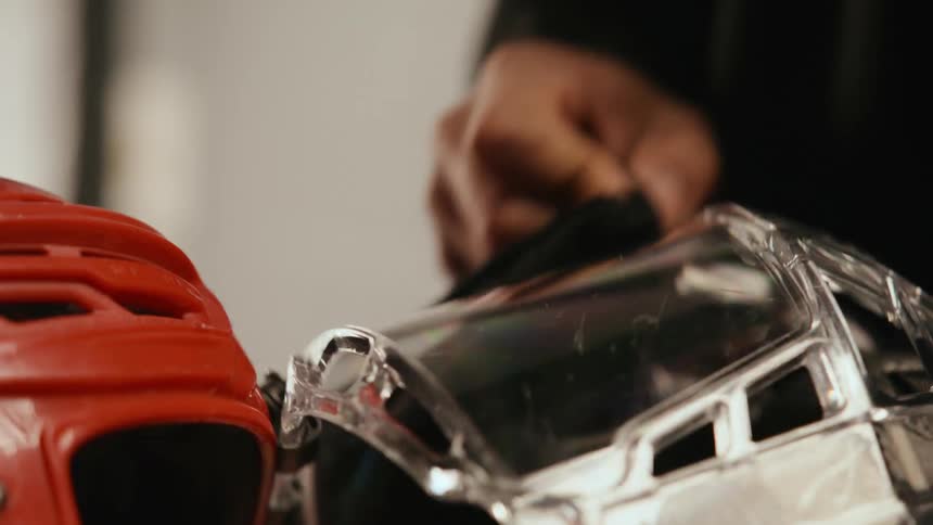 Closeup of a persons hand cleaning his hockey helmet