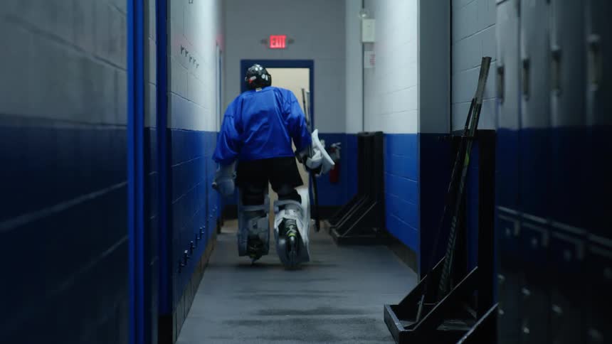 A clip of an hockey player walking through the corridor