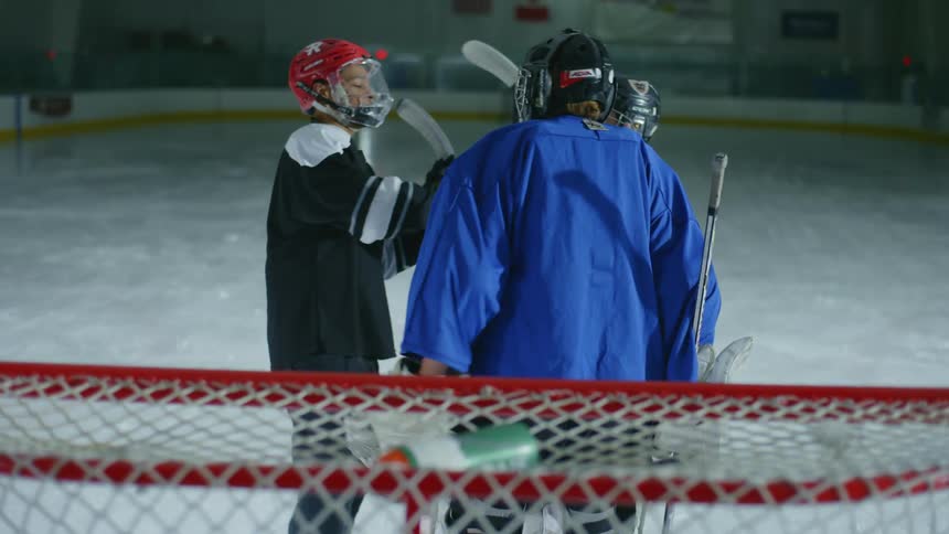 Hockey players hug near the goal on the ice rink