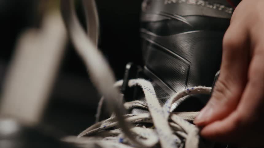 A hockey player lacing up skates