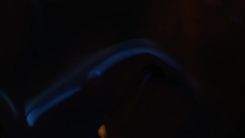 A translucent object appears to change color and shape as it rotates in the light