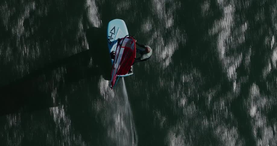 Aerial of a man windsurfing at high speed