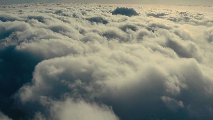 Sun shines through pale blue sky onto heavy cloud layer