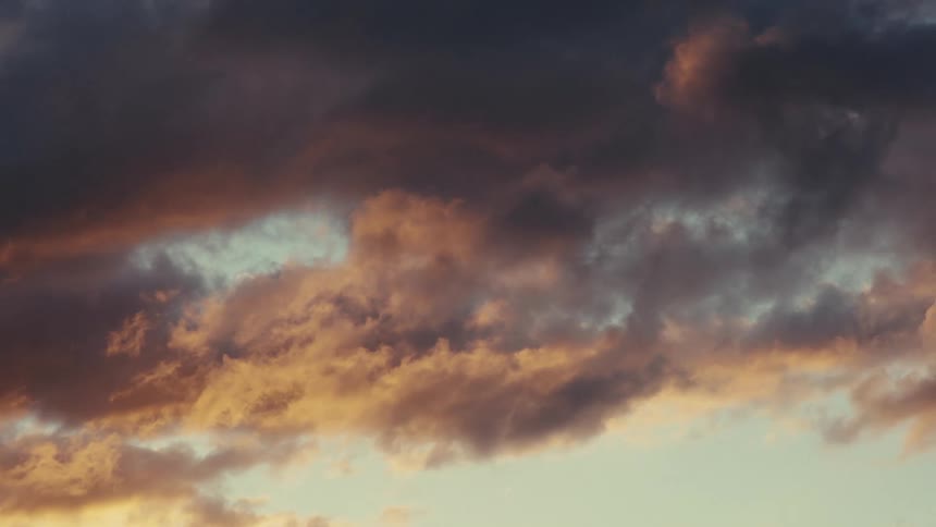 Dawn sky landscape with black clouds passing by