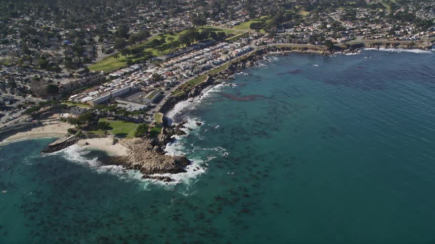 Aerial view of a coastal and urban area with turquoise waters and various rock formations