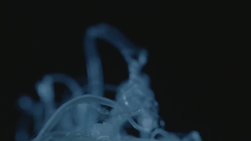 Some plastic tendrils move around in a dark area