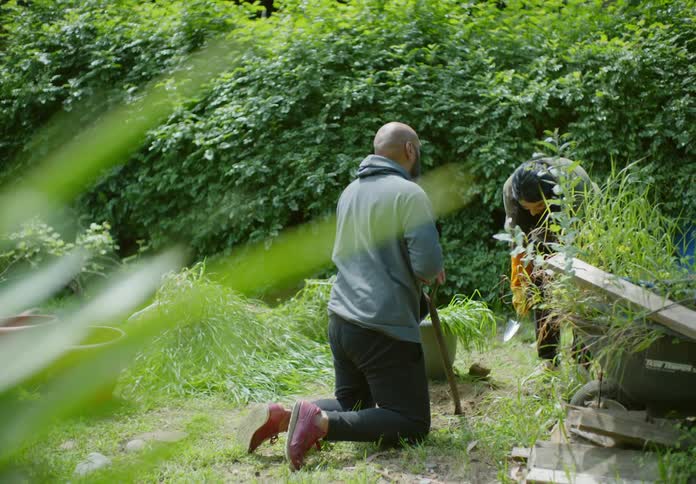 A clip of a male and female working on a garden