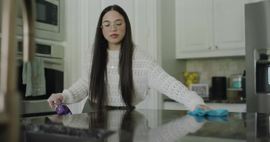 A woman is cleaning her kitchen counter