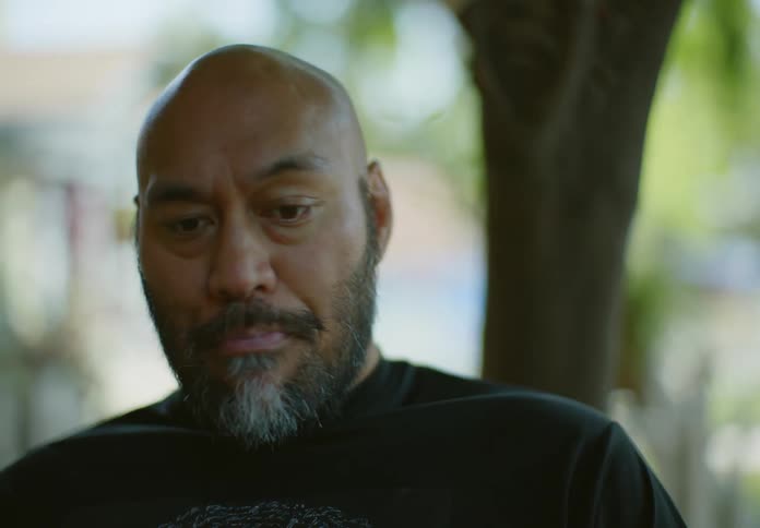 A man talks and drinks outside
